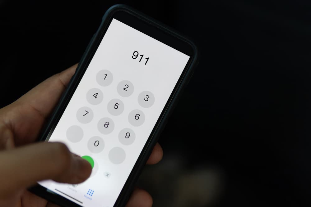  Una persona que sostiene un teléfono móvil en el que se ve el número 911, para destacar la importancia de llamar a los servicios de emergencia tras un accidente de tráfico en Illinois.