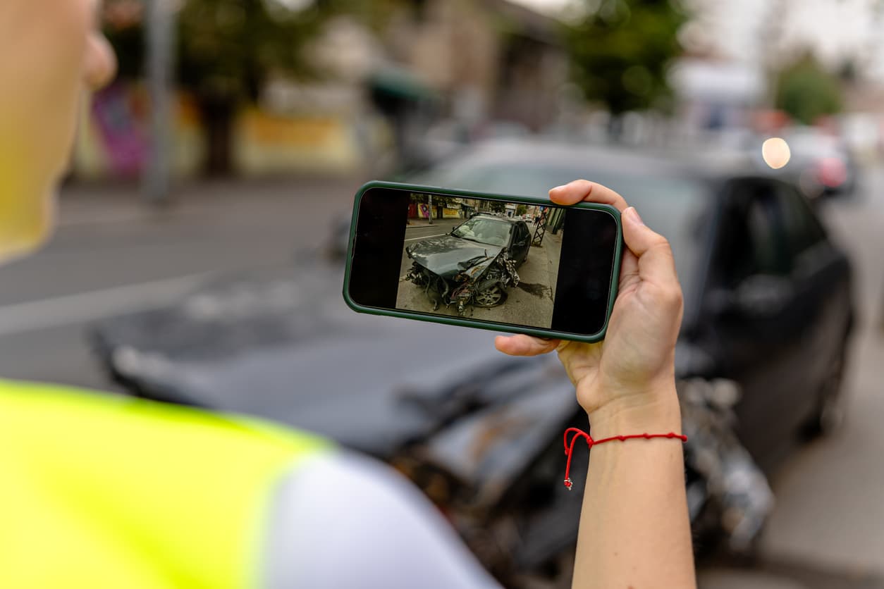 Una persona que fotografía el lugar de un accidente de tráfico, captando detalles con fines de documentación y para la elaboración de informes en Illinois.